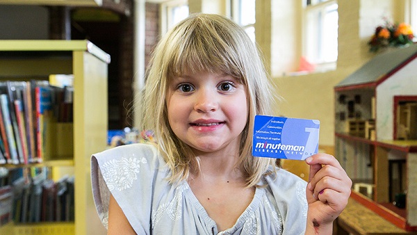 child holding Somerville library card