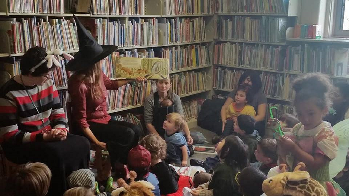 Librarian giving story time to children's group